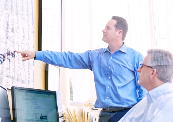 Two Coldwell Banker WESTMAC Commercial Brokerage Company agents looking at local map